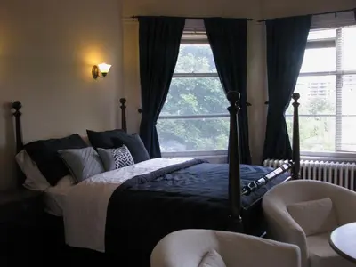 a bedroom with a bed and a large window at McBayne House in Hamilton