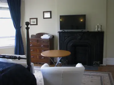a living room with a fireplace with a television and a table at McBayne House in Hamilton