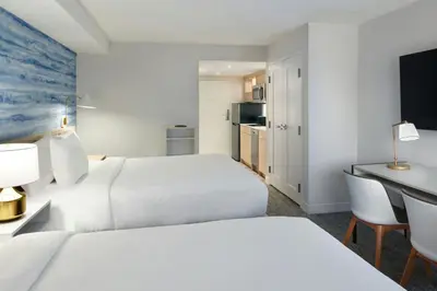 a hotel room with two beds and a desk at TownePlace Suites by Marriott Niagara Falls Canada in Niagara Falls