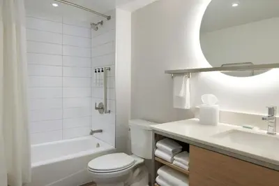 a white bathroom with a toilet and a sink at TownePlace Suites by Marriott Niagara Falls Canada in Niagara Falls