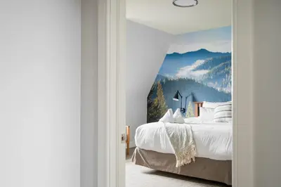 a bedroom with a bed with a mountain mural at Beautiful & Bright 3 Bed Townhome Near Village in Blue Mountains