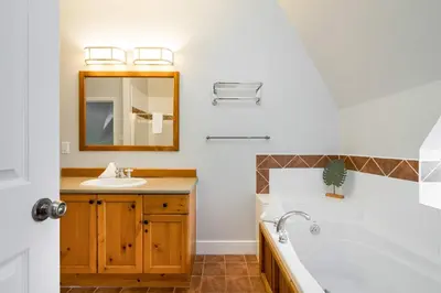 a bathroom with a sink and a tub and a mirror at Beautiful & Bright 3 Bed Townhome Near Village in Blue Mountains