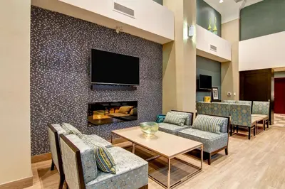 a living room with a fireplace and a tv on a wall at Hampton Inn London Ontario in London