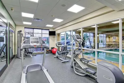 a gym with treadmills and a swimming pool at Hampton Inn London Ontario in London
