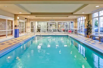 a swimming pool with blue water in a building at Hampton Inn London Ontario in London