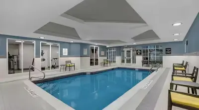 a large swimming pool with blue water in a building at Homewood Suites by Hilton London Ontario in London