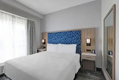 a bedroom with a large bed and a blue wall at Homewood Suites by Hilton London Ontario in London