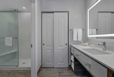 a white bathroom with a sink and a mirror at Homewood Suites by Hilton London Ontario in London