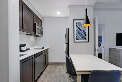 a kitchen with a white counter top and a table at Homewood Suites by Hilton London Ontario in London