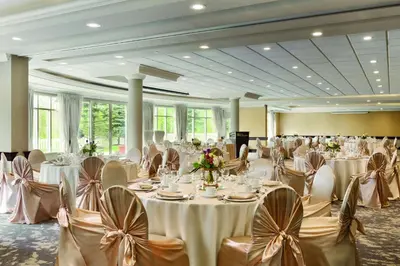 a banquet hall with white tables and chairs with flowers at Hilton Garden Inn Niagara-on-the-Lake in Niagara on the Lake