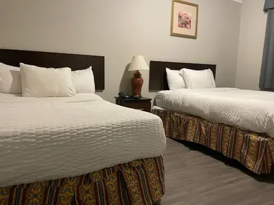 a hotel room with two beds and a lamp at London Residency Inn in London