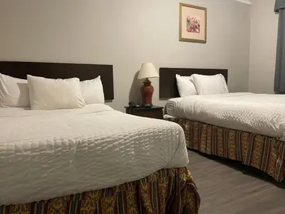 a hotel room with two beds and a lamp at London Residency Inn in London