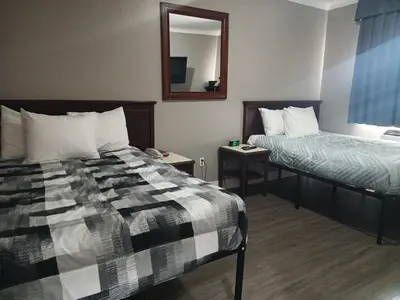 a hotel room with two beds and a mirror at London Residency Inn in London