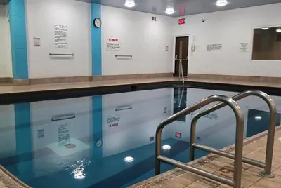 a swimming pool with blue water in a room at Travelodge by Wyndham Simcoe in Simcoe