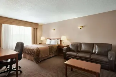 a hotel room with a bed and a couch at Travelodge by Wyndham Simcoe in Simcoe