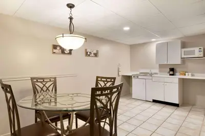 a kitchen and dining room with a glass table and chairs at Travelodge by Wyndham Simcoe in Simcoe