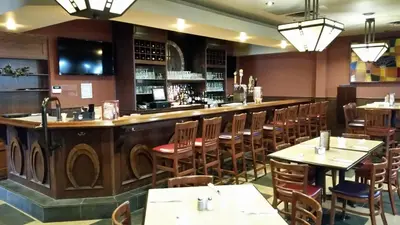 a restaurant with a bar with tables and chairs at Travelodge by Wyndham Simcoe in Simcoe