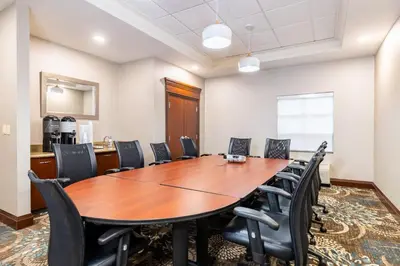 a conference room with a wooden table and chairs at Staybridge Suites London by IHG in London