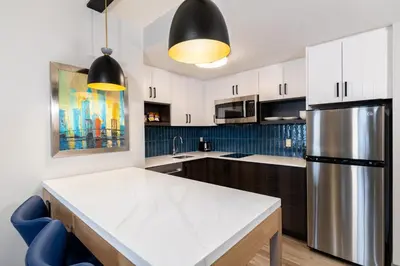 a kitchen with white cabinets and a refrigerator at Staybridge Suites London by IHG in London