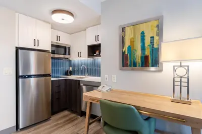 a kitchen with a wooden table and a refrigerator at Staybridge Suites London by IHG in London