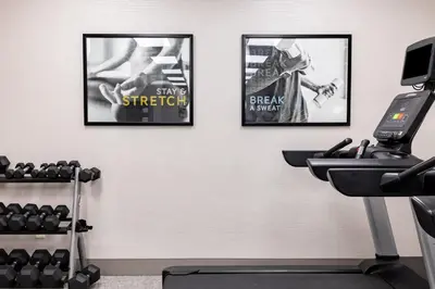 a gym with three posters on the wall at Staybridge Suites London by IHG in London