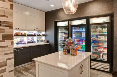 a kitchen with a refrigerator filled with drinks at Homewood Suites by Hilton Burlington in Burlington