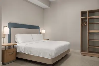 a bedroom with a bed and a book shelf at Homewood Suites by Hilton Burlington in Burlington