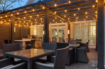 an outdoor patio with tables and chairs and lights at Homewood Suites by Hilton Burlington in Burlington