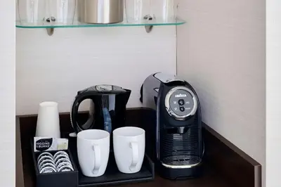a black coffee maker and cups on a shelf at Radisson Blu Toronto Downtown in Toronto