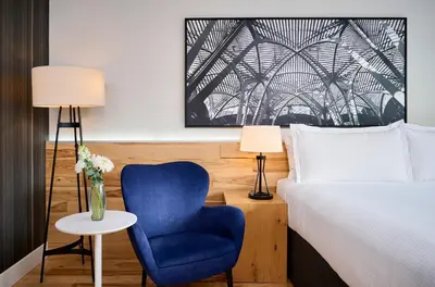 a bedroom with a bed and a blue chair at Radisson Blu Toronto Downtown in Toronto