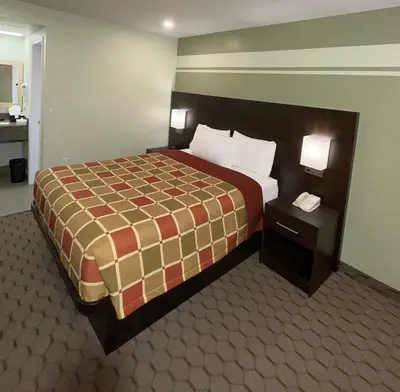 a hotel room with a large bed and two night stands at Budget Inn in Port Hope