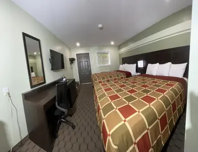 a hotel room with two beds and a television at Budget Inn in Port Hope