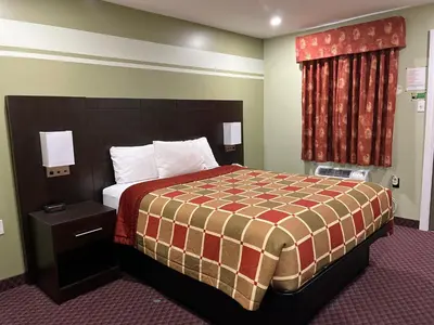 a hotel room with a bed and a window at Budget Inn in Port Hope