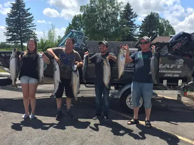 a group of people holding up their fish at Budget Inn in Port Hope