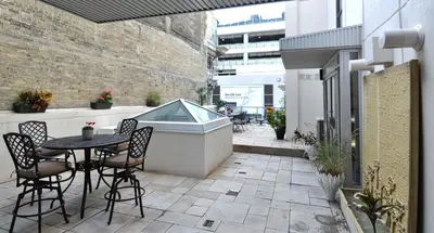 a patio with a table and chairs and a bath tub at Yonge Suites Apart Hotel in Toronto