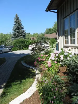 a garden of flowers in front of a house at Cedar Gables Bed & Breakfast in Niagara on the Lake