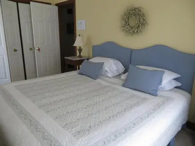 a bedroom with a large bed with a blue headboard at Cedar Gables Bed & Breakfast in Niagara on the Lake