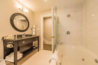 a bathroom with a tub and a sink and a mirror at Idlewyld Inn & Spa in London