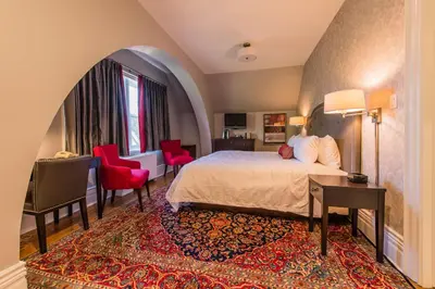 a hotel room with a bed and a desk and chairs at Idlewyld Inn & Spa in London