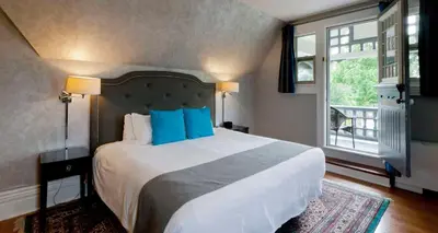 a bedroom with a large bed with blue pillows at Idlewyld Inn & Spa in London
