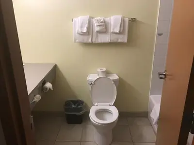 a bathroom with a toilet and towels on the wall at Super 8 by Wyndham Barrie South in Barrie