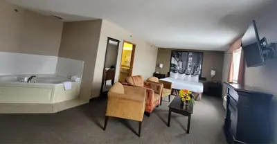 a hotel room with a tub and a bed at Super 8 by Wyndham Barrie South in Barrie