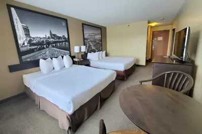 a hotel room with two beds and a table at Super 8 by Wyndham Barrie South in Barrie