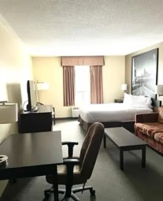 a hotel room with a bed and a couch at Super 8 by Wyndham Barrie South in Barrie