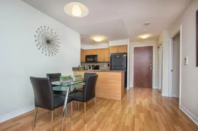 a kitchen and dining room with a table and chairs at Platinum Suites Furnished Executive Suites in Mississauga