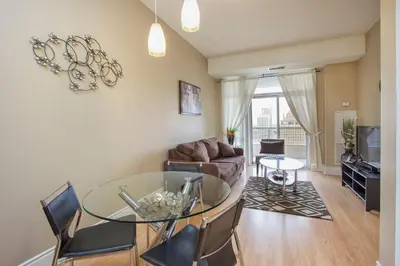 a living room with a glass table and a couch at Platinum Suites Furnished Executive Suites in Mississauga