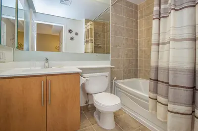 a bathroom with a toilet and a sink and a tub at Platinum Suites Furnished Executive Suites in Mississauga