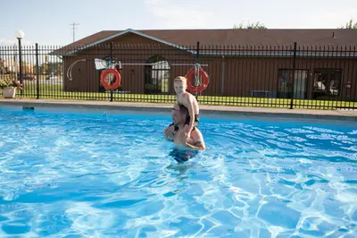 a man and woman standing in a swimming pool at Super 8 by Wyndham Port Elgin in Port Elgin