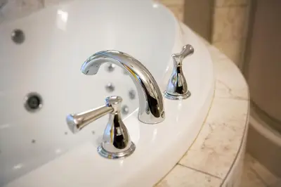 a white sink with two faucets on it at Super 8 by Wyndham Port Elgin in Port Elgin