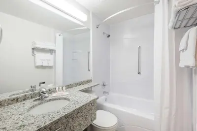 a white bathroom with a sink and a toilet at Super 8 by Wyndham Port Elgin in Port Elgin